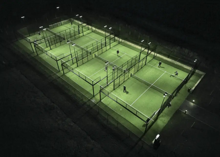 Aerial view of floodlit padel courts at night — premium padel court supply and installation UK